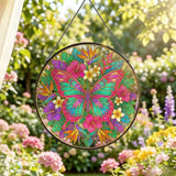 Large butterfly glass suncatcher with gold-lined wings amid pink, teal, and purple floral burst with hanging chain
