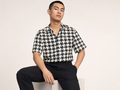 Male model wearing the Rich and Rich Men’s Brown Multicolor Houndstooth Designer Shirt with a boxy fit, short sleeves, notch lapel collar, and bold houndstooth pattern.