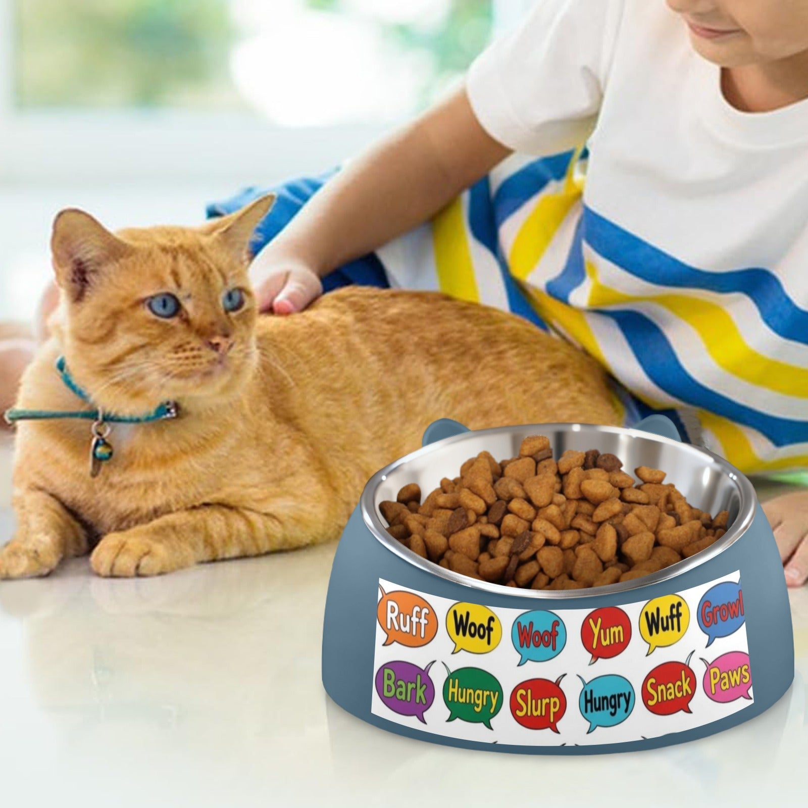 Orange tabby cat eating from colorful custom pet bowl with speech bubble pattern