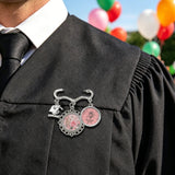 Pink roses and musical notes brooch with two round photo charms and a graduation cap charm — rear view