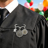 Black and gold baroque-style brooch with two round photo charms and a graduation cap charm — rear view