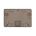 Flat lay of taupe area rug with scrolling vine pattern and concentric square motif