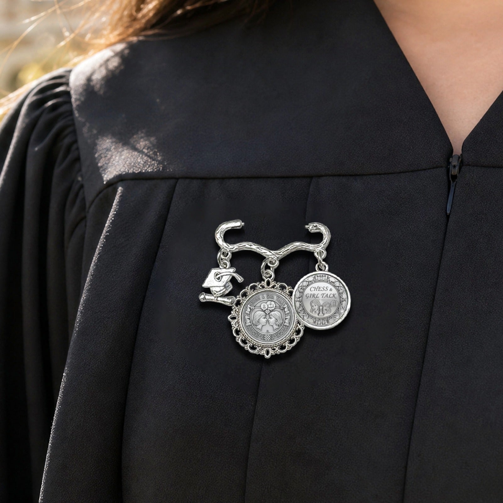 Chess Girl Talk decorative metal brooch with two round photo charms and a small graduation cap charm on a pin — side view