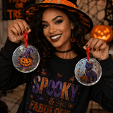 Two round crystal glass Halloween ornaments with pumpkin and black cat designs and included hanging ropes