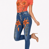 Coral tee with large orange and gold tiger lily blooms paired with high-waist denim embroidered with matching flo — side view