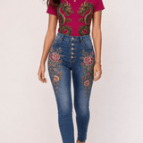 Fuchsia tee with gold and emerald twin dragon graphic paired with denim embroidered with floral and scale motifs — side view