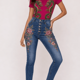 Fuchsia tee with gold and emerald twin dragon graphic paired with denim embroidered with floral and scale motifs — rear view