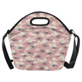 A pink neoprene lunch bag with a floral pattern, featuring a top handle, zipper closure, and adjustable shoulder straps on a white background.