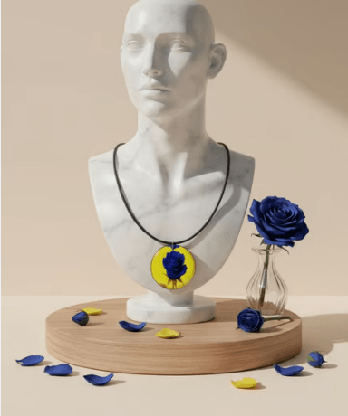 Organic-shaped wooden pendant with yellow and blue rose print on a black faux suede cord and silver clasp — alternate view