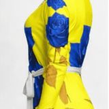 Yellow and blue rose wrap dress with V-neck, long sleeves and belt tie, above-knee length — side view