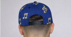 Blue cap with musical note designs on a plain background