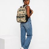 Beige 17-inch backpack with front pocket, mesh side pockets, padded straps, and orange buckle detail