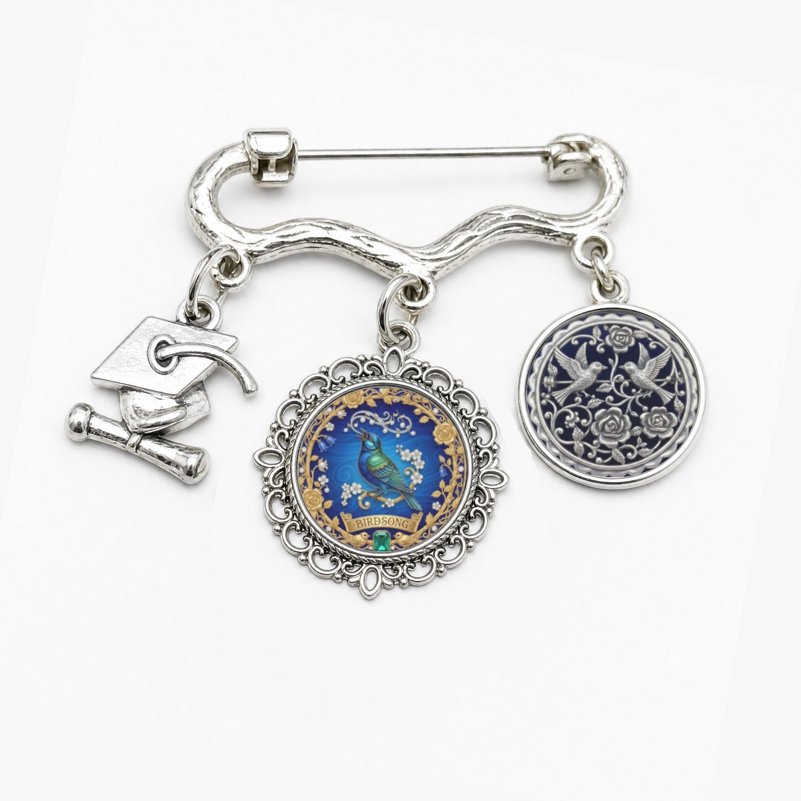 Floral brooch with birdsong motif, two round photo charms and a graduation cap charm