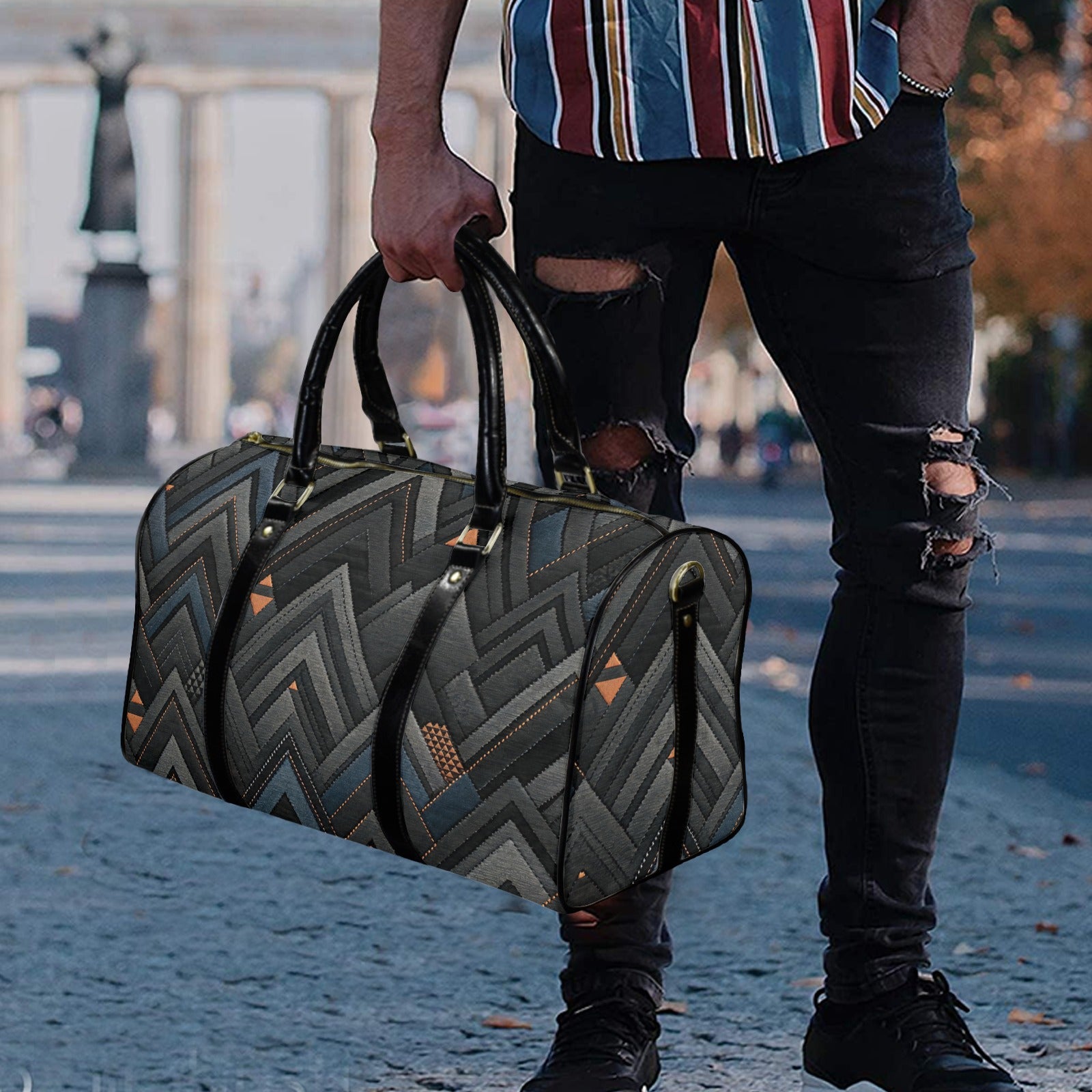 Person holding a patterned duffel bag outdoors