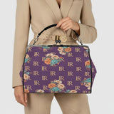 Purple floral kisslock crossbody bag in waxed PU with removable shoulder strap and top handle