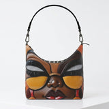 Square brown hobo bag with hand-painted ethnic caricature artwork and a single shoulder strap — side view