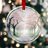 Round crystal glass ornament with pink cherry blossom tree artwork and coordinating hanging ribbon — side view