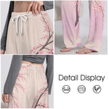 Pink drawstring lounge pants with Japanese cherry blossom print and elastic waistband, shown folded — side view